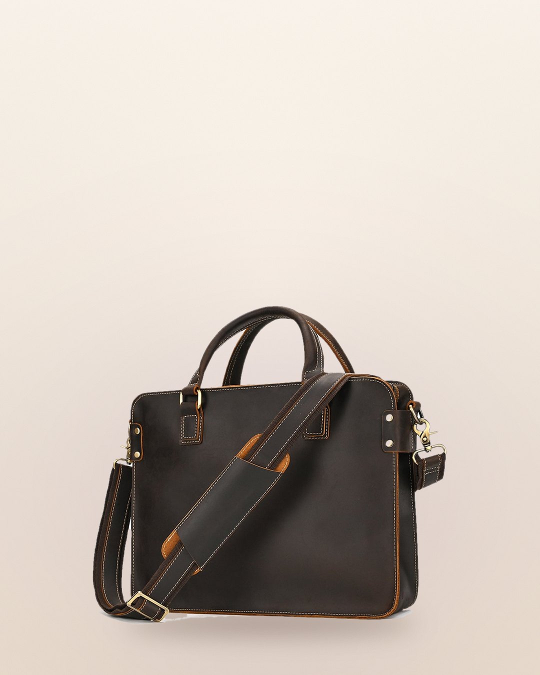 Dark brown briefcase with two top handles and a shoulder strap on a cream background